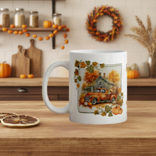 Load image into Gallery viewer, White mug with autumn-themed design featuring a truck and pumpkins on a wooden table.