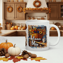 Load image into Gallery viewer, White mug with 'Autumn Bliss' design in a kitchen setting with pumpkins and leaves.