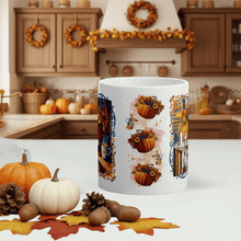 Load image into Gallery viewer, White mug with autumn-themed design in a kitchen setting with pumpkins and leaves.
