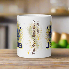 Load image into Gallery viewer, Back side view of the white glossy mug with the phrase "The Good Shepherd" and Bible verse John 10:11, with golden sparkles in the background.
