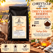 Load image into Gallery viewer, A bag of Chiefy's Cup Coffee Co. Chiefy's Sunrise Reserve Breakfast Blend ground coffee is shown in a styled coffee-themed scene with coffee beans, a honey pot, almonds, and text callouts on a warm beige background.
