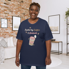 Load image into Gallery viewer, Woman wearing a navy blue t-shirt with a coffee-themed design in a living room.