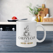 Load image into Gallery viewer, Right side view of white glossy mug featuring the Chiefy’s Cup logo with the image phrase "Chiefy’s Cup," showing a black cup and saucer with black steam rising from the cup.