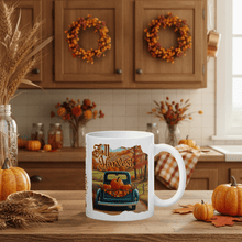 Load image into Gallery viewer, White mug with 'Fall Harvest' design in a kitchen setting with pumpkins and wreaths.