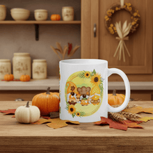 Load image into Gallery viewer, White mug with a fall-themed design featuring pumpkins and sunflowers on a wooden table.