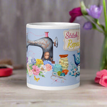 Load image into Gallery viewer, Back side view white glossy mug with the phrase "Stitch Sip Repeat," displaying a vintage sewing machine surrounded by sewing accessories and a light blue lace frame.
