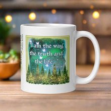 Load image into Gallery viewer, Right side view of a white glossy mug featuring the phrase "I am the way, the truth, and the life" with the Bible verse John 14:6, accompanied by a starry sky, glowing pine trees, golden lights, and translucent butterflies.