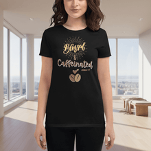 Load image into Gallery viewer, Front view of a woman wearing a black “Blessed & Caffeinated” t-shirt featuring golden lettering with a coffee bean graphic. The shirt is displayed in a softly lit modern indoor setting, creating a bright, uplifting coffee-inspired vibe.