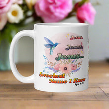 Load image into Gallery viewer, Left side view white glossy mug featuring the phrase "Jesus, Jesus, Jesus, Sweetest Name I Know" with a pastel floral arrangement, a blue mockingbird, swaying musical notes, and a light pink hue circle background with a Bible verse.
