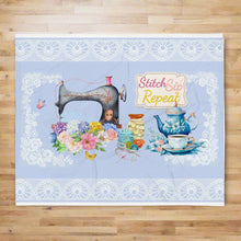 Load image into Gallery viewer, Front view  50″×60″ throw blanket  with image image phrase stitch sip repeat, with image design vintage sewing machine, with floral bouquet, with sewing accessories, with vintage kettle with cup and saucer, with lace border, with light blue background