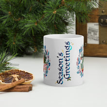 Load image into Gallery viewer, Back side view of a white glossy mug with the phrase "Season's Greetings" in beautiful festive blue font, accented with golden sparkles and small holly details.