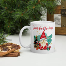 Load image into Gallery viewer, Left side view of a white glossy mug with the image phrase "Gnome for Christmas," featuring a gnome in a red hat, a small green decorated Christmas tree, small gifts, cups of hot drinks, a watercolor aqua background, and golden stars.