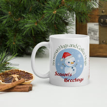 Load image into Gallery viewer, Left side view of white glossy mug with the phrase "Season's Greetings" in festive font, featuring a dancing snowman with snowflakes falling, set against a blue circle background.
