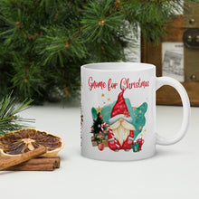 Load image into Gallery viewer, Right side view of a white glossy mug with the image phrase "Gnome for Christmas," featuring a gnome in a red hat, a small green decorated Christmas tree, small gifts, cups of hot drinks, a watercolor aqua background, and golden stars.