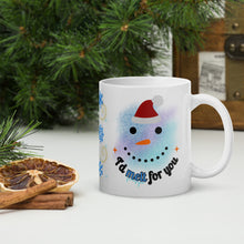 Load image into Gallery viewer, Right side view white glossy mug with the phrase "I'd melt for you" in festive font, featuring a smiling snowman face with a red cap and blurry bluish hues in the background.