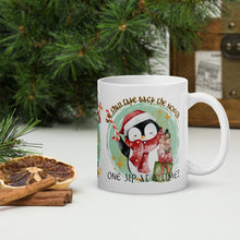 Load image into Gallery viewer, Right side view of a white glossy mug with an image of a cute penguin holding a candy cane, standing next to presents, with a light green-hued circle in the background and the phrase "We shall take back the North one sip at a time."