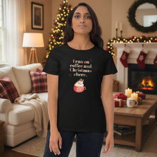 Load image into Gallery viewer, Woman wearing a black t-shirt with festive text in a cozy living room decorated for Christmas.