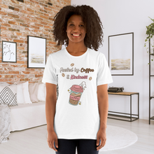 Load image into Gallery viewer, Woman wearing a white t-shirt with a coffee-themed design in a living room.
