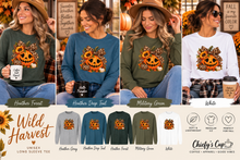 Load image into Gallery viewer, A promotional collage showing four women modeling long-sleeve graphic T-shirts with a pumpkin jack-o'-lantern design. The shirts are shown in multiple colors: athletic heather, heather forest green, heather deep teal, military green, and white.
