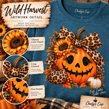 Load image into Gallery viewer, A graphic design mockup on a heather teal t-shirt showing a large autumn pumpkin illustration with a leopard-print bow, sunflowers, berries, and smaller pumpkins. The image includes promotional text overlays reading 'Wild Harvest Artwork Detail' and 'Chiefy's Cup', plus three circular detail callouts highlighting the print quality.
