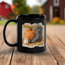 Load image into Gallery viewer, Black mug with a country-themed design featuring a pumpkin, boot, and cup on a wooden surface.
