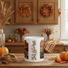 Load image into Gallery viewer, White mug with &#39;Fall Harvest&#39; design in a kitchen setting with pumpkins and wreaths.
