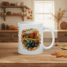 Load image into Gallery viewer, White mug with autumn-themed design featuring a truck and leaves on a wooden table.

