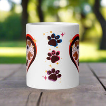 Load image into Gallery viewer, Back side view of a white glossy mug with one pink, one blue, and one purple paw print, surrounded by golden sparkles.
