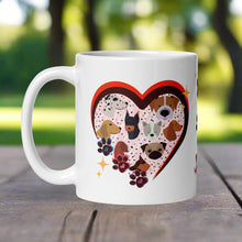 Load image into Gallery viewer, Left side view of a white glossy mug with a bright heart-shaped frame , surrounded by golden sparkles, with one pink, one blue, and one purple paw print on the side of the frame and cute dog faces inside the heart frame.
