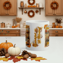 Load image into Gallery viewer, White mug with autumn-themed design in a kitchen setting with pumpkins and leaves.
