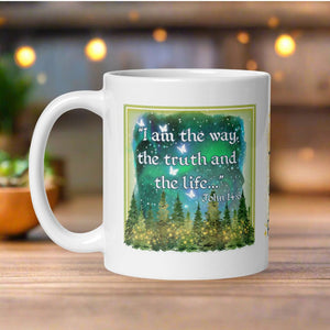 Left side view of a white glossy mug featuring the phrase "I am the way, the truth, and the life" with the Bible verse John 14:6, accompanied by a starry sky, glowing pine trees, golden lights, and translucent butterflies.