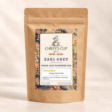 Load image into Gallery viewer, A kraft paper stand-up pouch of Chiefy's Cup Tea Co. Earl Grey loose leaf flavored tea, featuring a floral border and a white central label, photographed against a warm off-white background.
