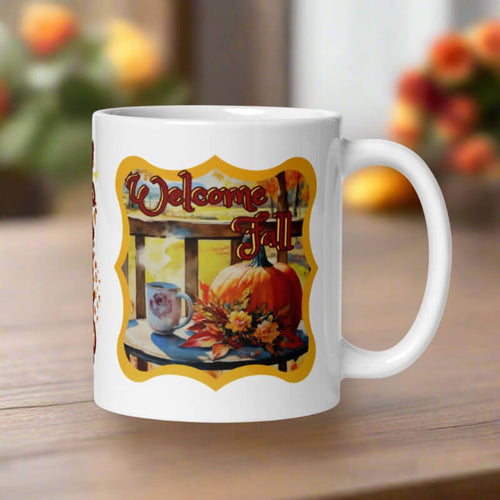 White mug with 'Welcome Fall' design featuring pumpkins and flowers on a wooden surface.