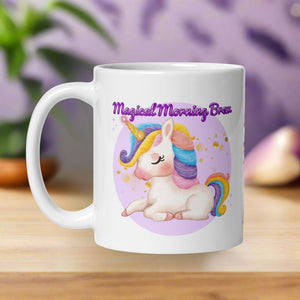 Left side view of a white glossy mug featuring the phrase "Magical Morning Brew" and a colorful-maned white unicorn with a golden horn, surrounded by golden sparkles and set against a purple circular background.