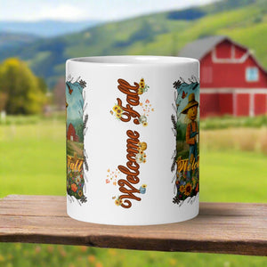 Back side view of a white glossy mug with the phrase "Welcome Fall" in festive font, showcasing small pumpkins, blowing leaves, and bright sunflowers.