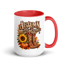 Load image into Gallery viewer, A white ceramic mug with a red interior and red handle, featuring a western-themed autumn graphic with the text 'AUTUMN on the Range' above cowboy boots, pumpkins, sunflowers, and fall leaves.
