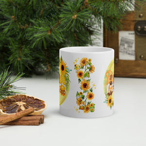 Back side view of a white glossy mug showcasing a stalk of sunflowers, small playful gnomes decorated with sunflower accents, a small pumpkin, and golden sparkles.