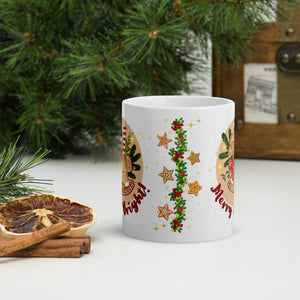 Back side view of a white glossy mug with a design of a festive garland with red bows, Christmas ornaments, gingerbread cookies, and golden sparkles in the background.