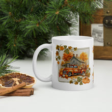 Load image into Gallery viewer, Left side view of a white glossy mug featuring an old orange truck with a bed full of pumpkins and harvest goods, set against a gray farmhouse in the background, with orange hues and an autumn frame surrounding the image.
