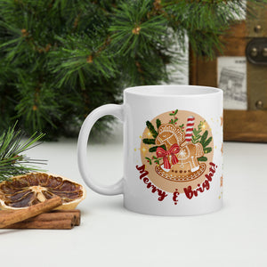 Left side view of a white glossy mug with the phrase "Merry and Bright" and a design featuring a gingerbread horse, pine branches, and golden sparkles in the background.