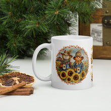 Load image into Gallery viewer, Left side view of a white glossy mug with a design of yellow sunflowers in front of a scarecrow, the scarecrow sipping coffee in a sunflower field on a farm, with butterflies and a fall frame.
