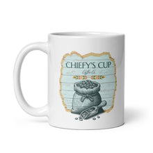 Load image into Gallery viewer, A white ceramic coffee mug featuring a rustic graphic design with the text 'CHIEFY'S CUP Coffee Co' and an illustration of a sack of coffee beans on a light blue wood-textured background.
