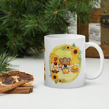 Load image into Gallery viewer, Right side view of a white glossy mug featuring a design of festive fall gnomes holding Thanksgiving desserts, encircled by a sunflower wreath on a yellowish-green background.
