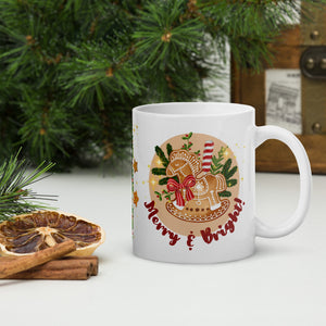 Right side view of a white glossy mug with the phrase "Merry and Bright" and a design featuring a gingerbread horse, pine branches, and golden sparkles in the background.