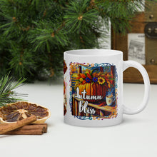 Load image into Gallery viewer, Right side view of white glossy mug with image phrase in festive font Autumn Bliss, with a vibrant fall colored  image design of a pumpkin on a farm porch next to a cup of a hot drink, with a vibrant arrangement of flowers on top of the pumpkin, with colorful frame
