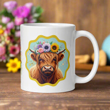 Load image into Gallery viewer, Right side view of a white mug showcasing a highland cow adorned with pink, white, purple flowers, and sunflowers surrounded by gold and pink sparkles, with a light blue background and yellow frame.
