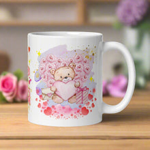 Load image into Gallery viewer, Right side view of a white glossy mug featuring a watercolor teddy bear holding a pink heart, with a floral heart behind it, surrounded by pink and golden accents, a purple splat in the background, and pink hearts around the teddy bear.


