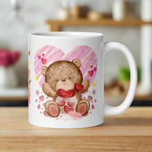 Load image into Gallery viewer, Right side view of a white glossy mug featuring a cute teddy bear pulling red hearts out of a jar, with pink hearts surrounding the bear, golden sparkles in the background, and a large pink heart behind the bear.

in country kitchen, wooden cabinets, warm happy sunlight coming into the window, plants, shelves, ingredients, commercial advertising photography
