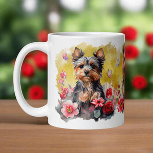 Left side view of a white glossy mug featuring a Yorkie puppy sitting among colorful flowers with a yellow background and butterflies completing the scene.